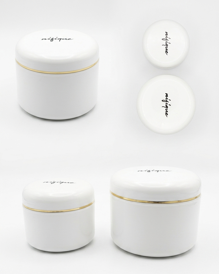 Set of white ceramic jars with gold rims on a white background