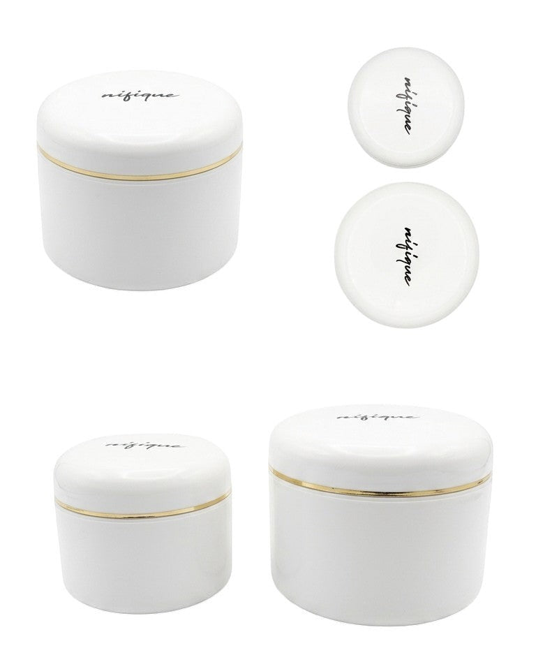 Set of white ceramic jars with gold rims on a white background