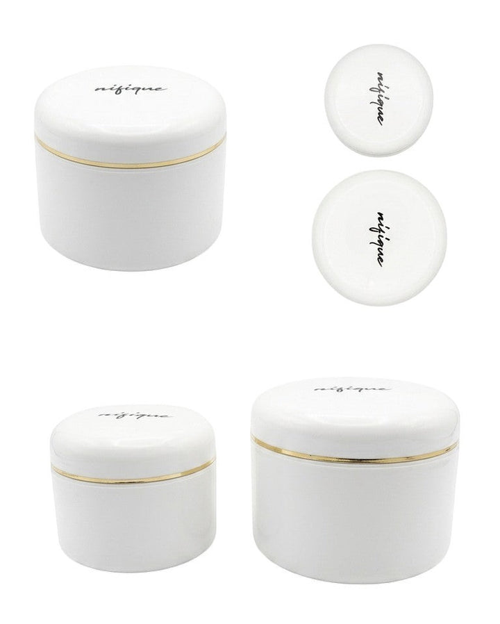 Set of white ceramic jars with gold rims on a white background