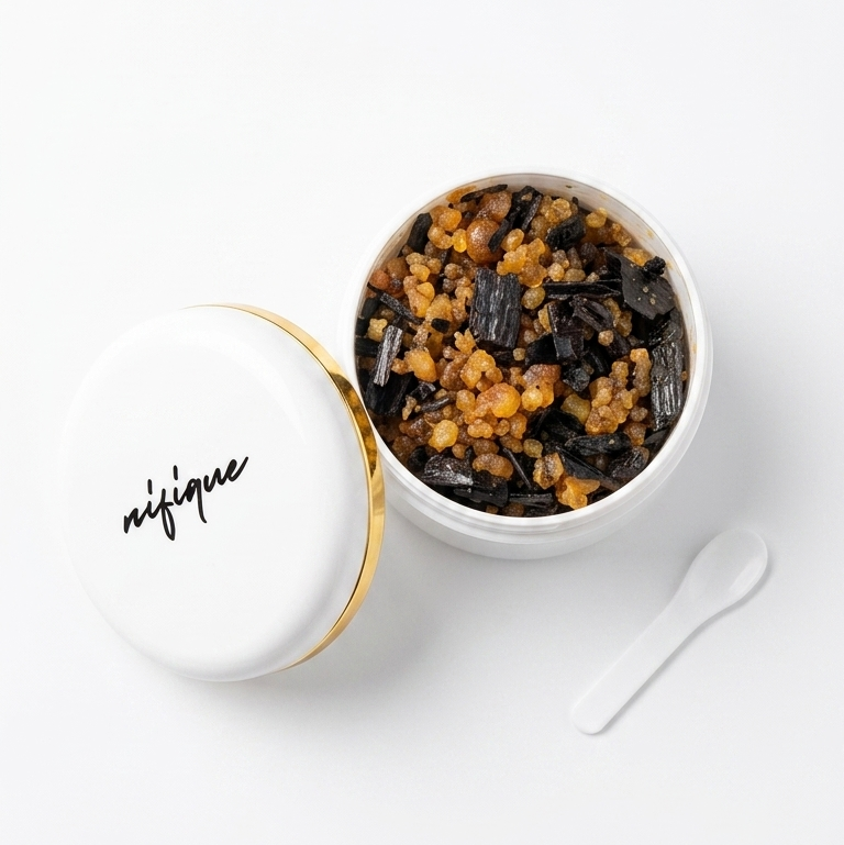 White bowl with black text containing a dark brown substance on a white background