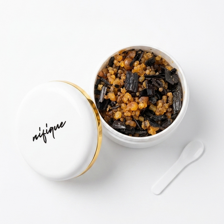 White bowl with black text containing a dark brown substance on a white background