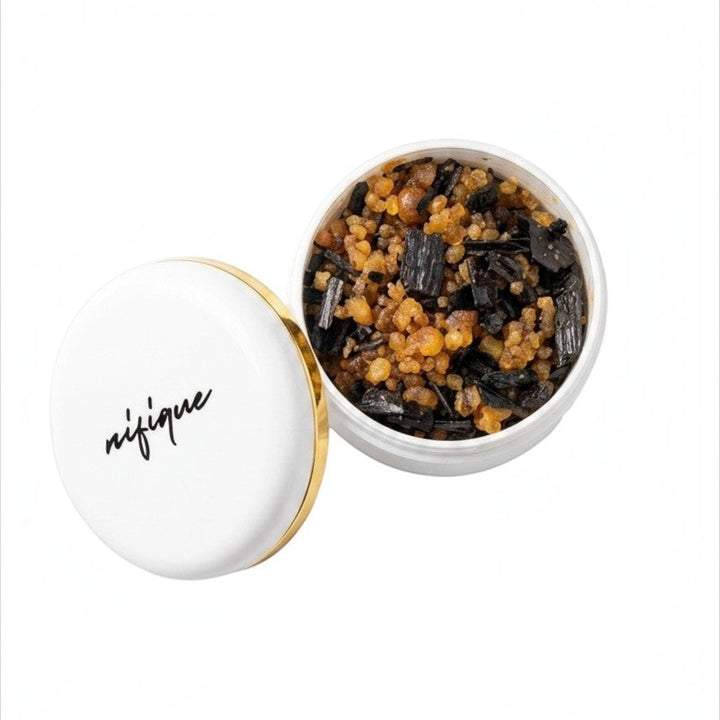 White bowl with black text containing a dark brown substance on a white background