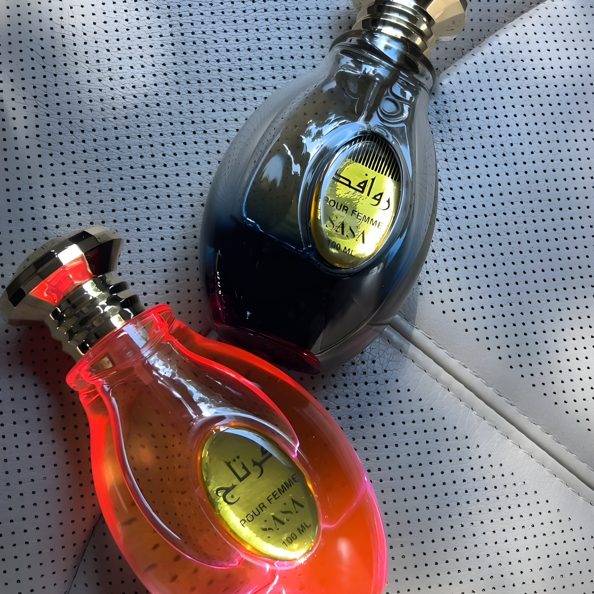 Two bottles of perfume on a textured surface